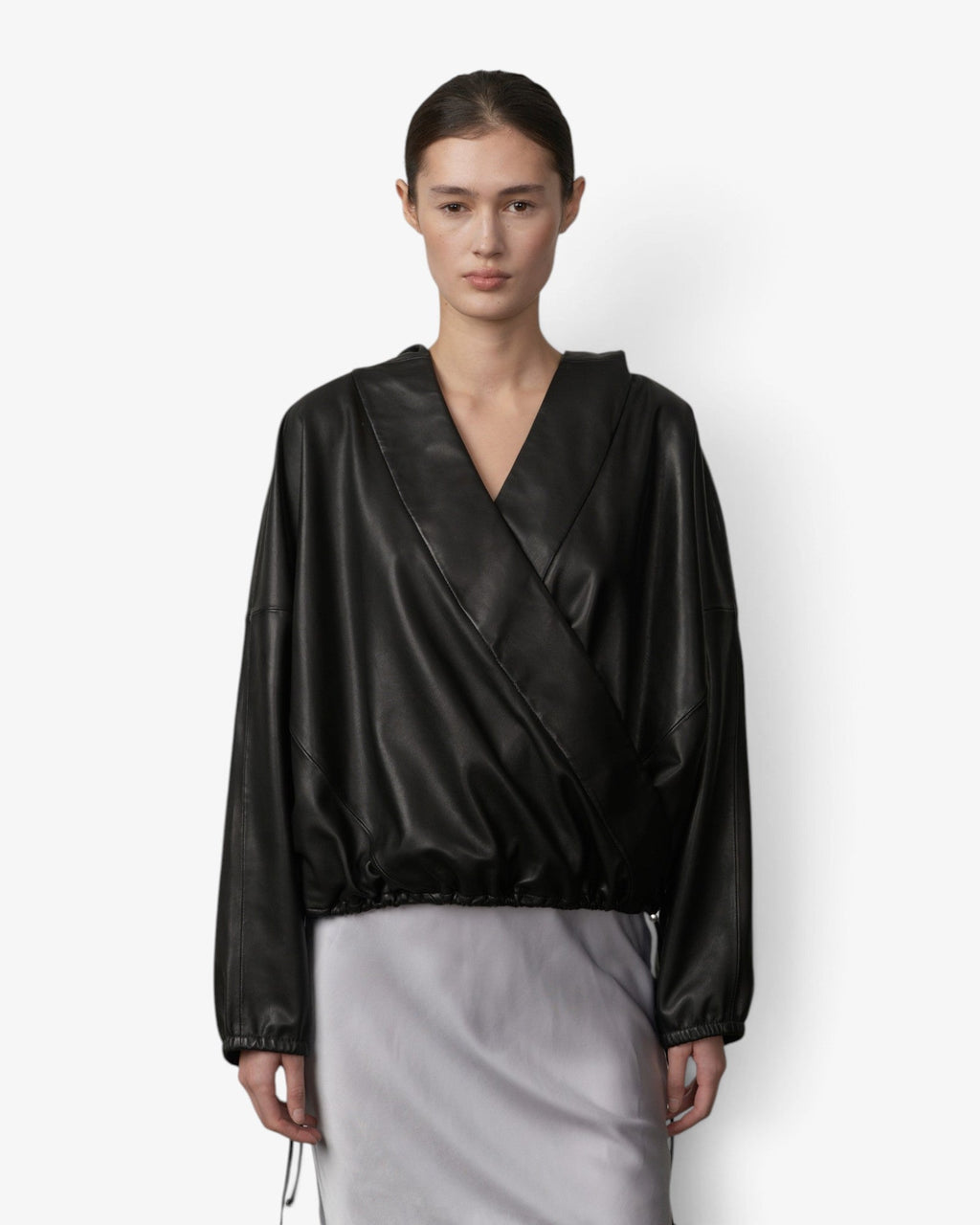 She Stories Herskind Sisi black leather hooded blouse with long sleeves worn with a grey lace-trimmed skirt