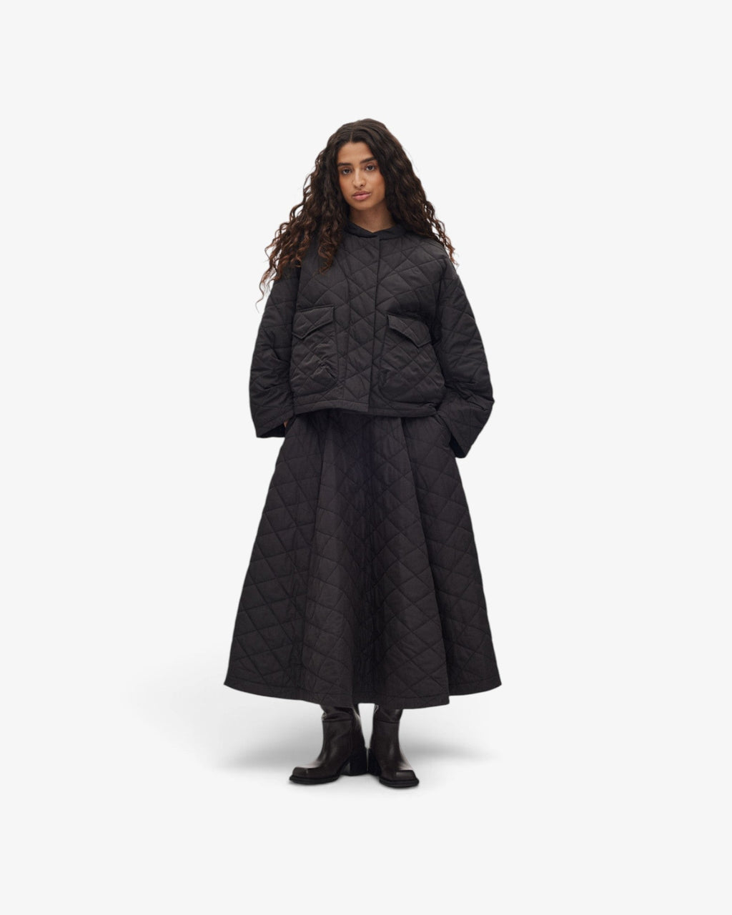 She Stories model wearing a black Rabens Saloner Rhea quilted tech jacket with a hood and oversized boxy fit.